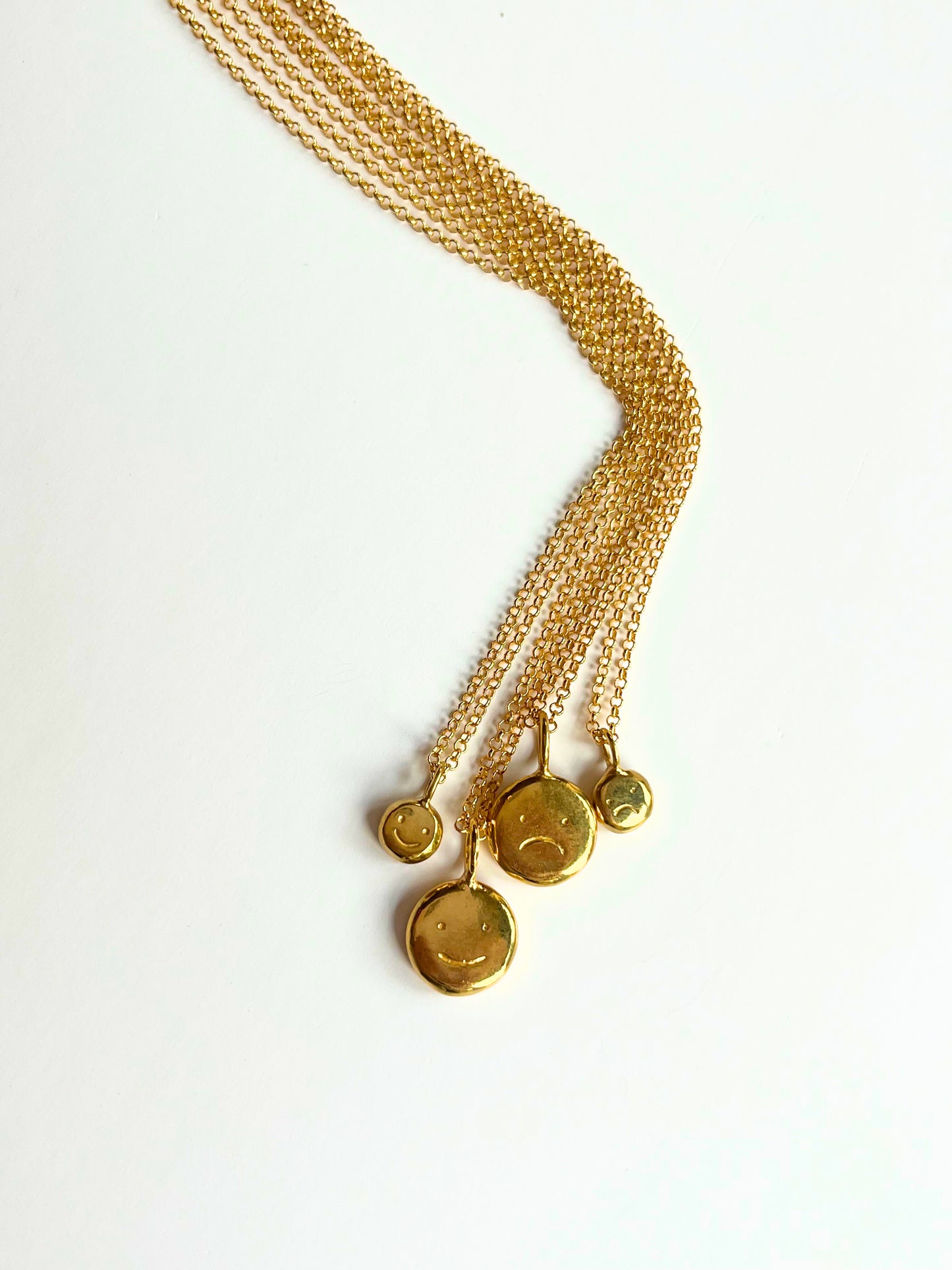 Gold baby "moodflip" smiley pendant