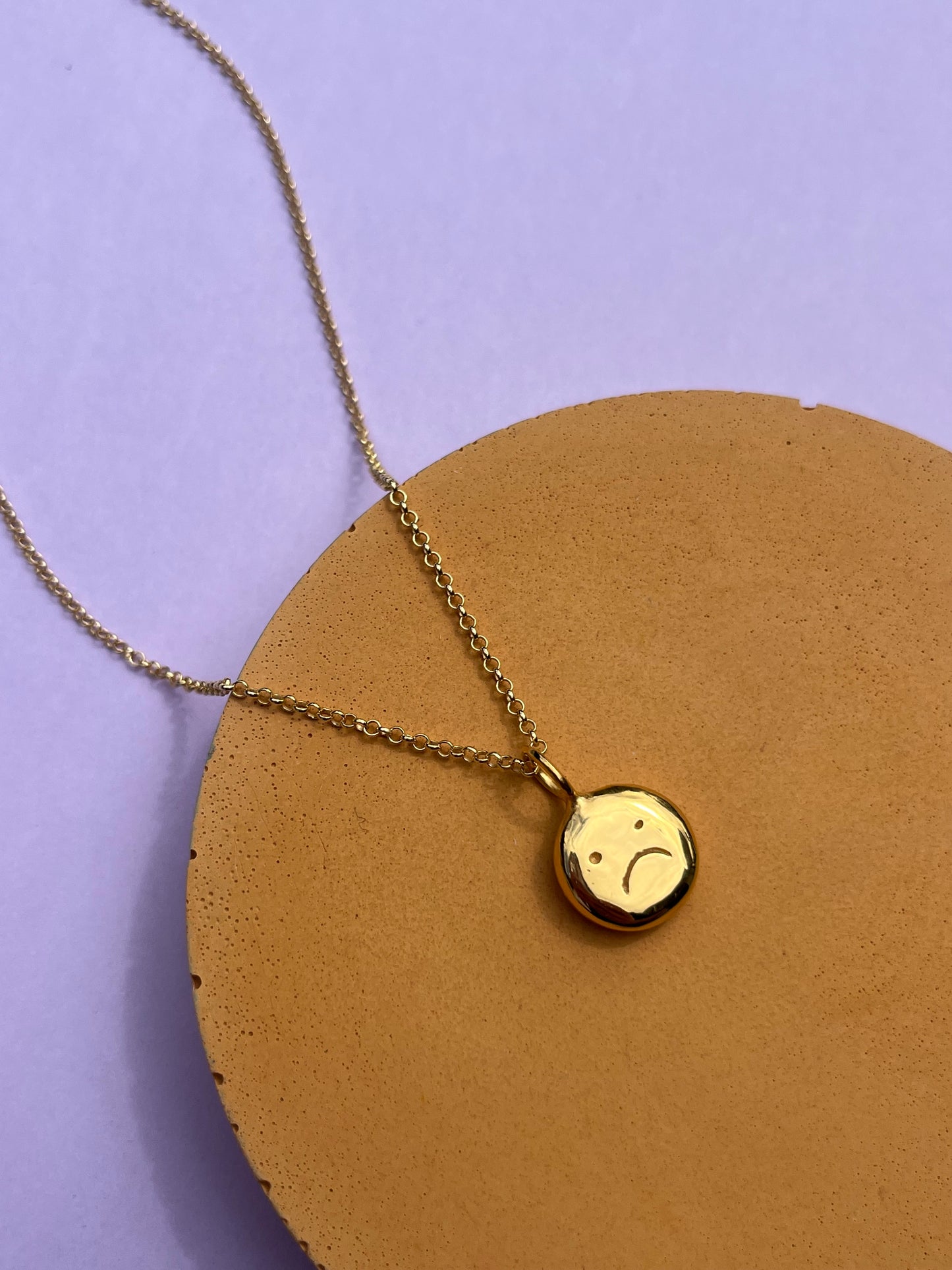 Gold plated sad face smiley pendant