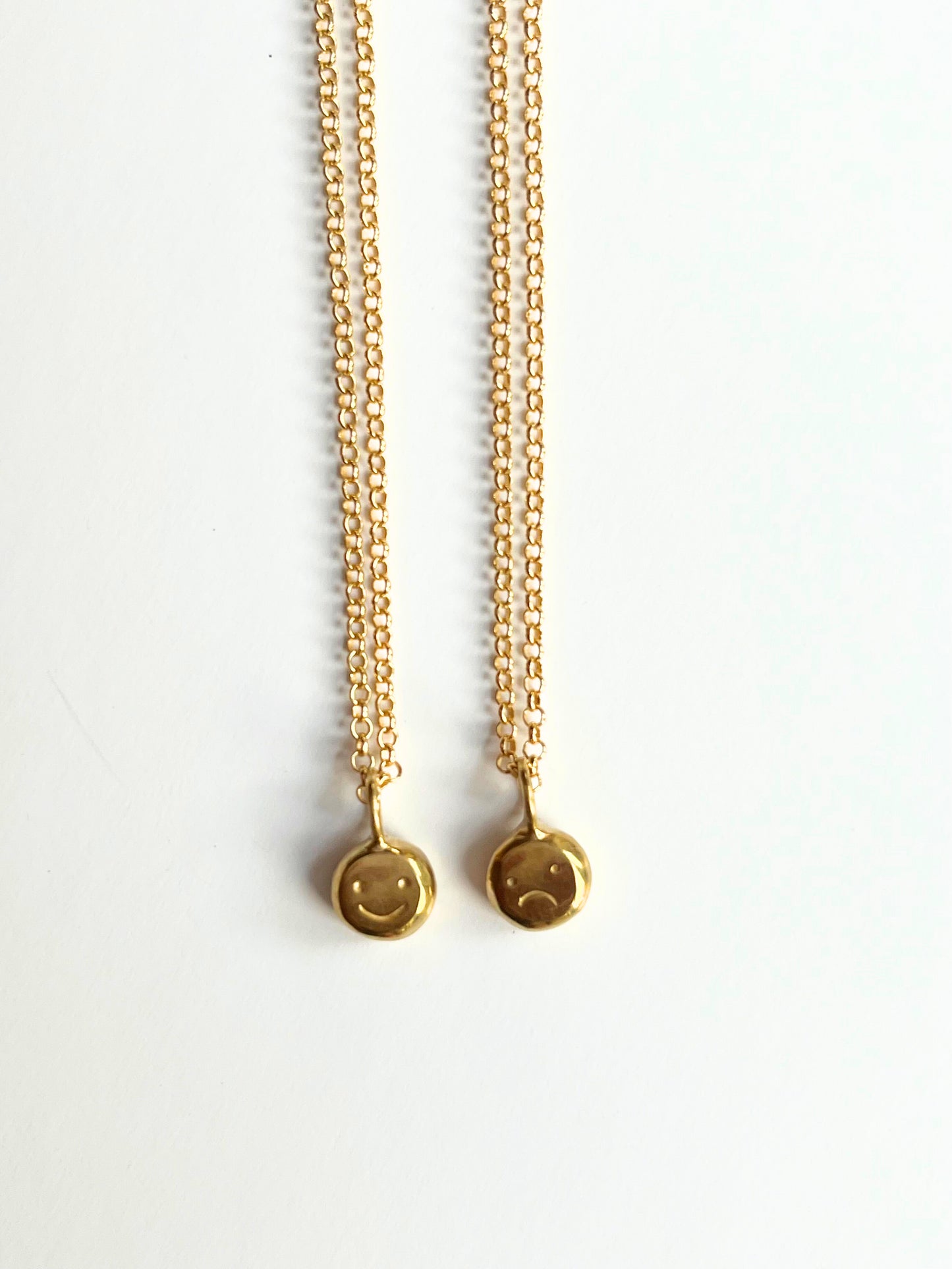 Gold baby "moodflip" smiley pendant