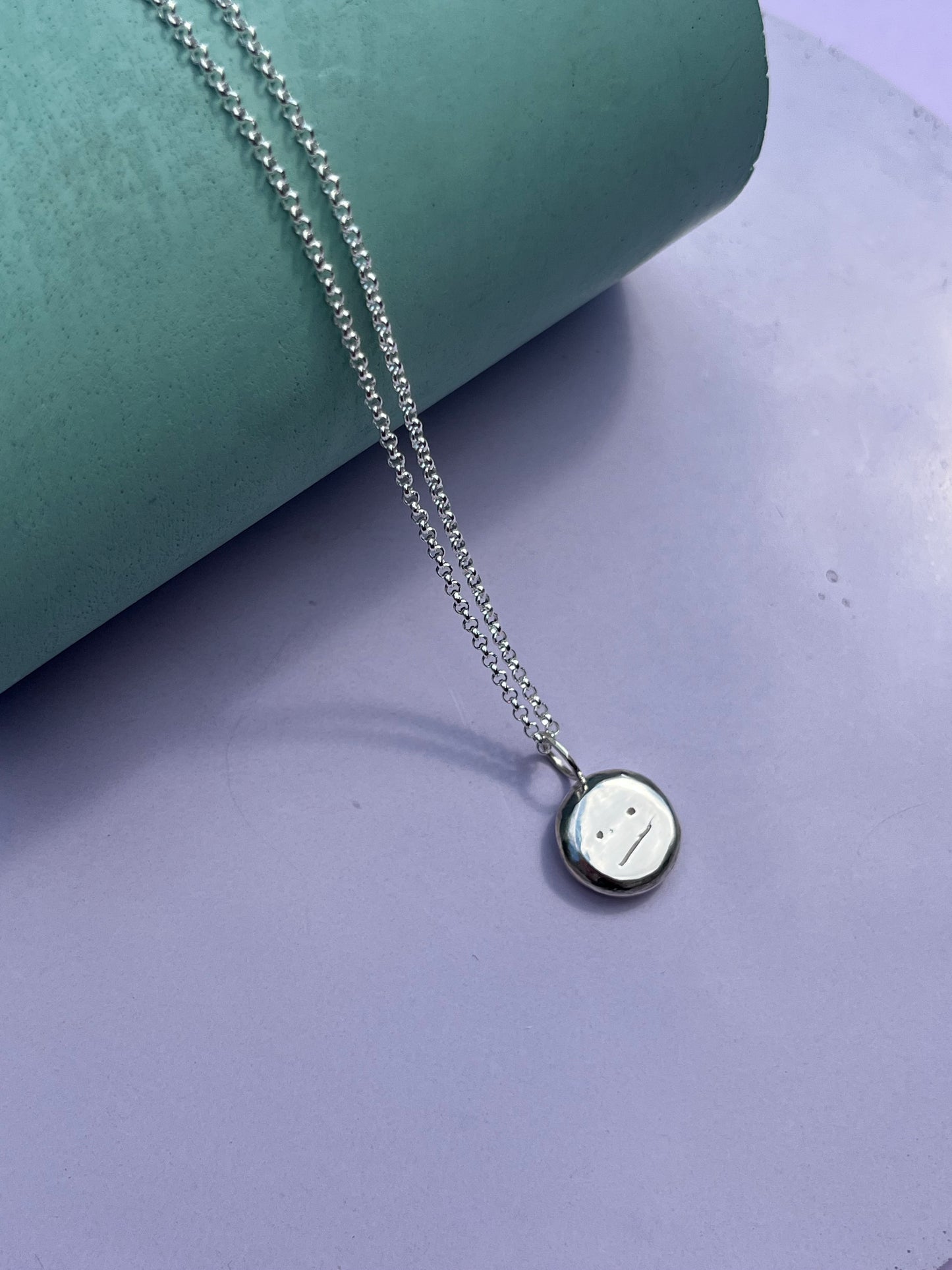 Silver “meh” smiley pendant